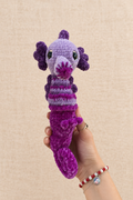 Hippocampe violet, vue de face sur fond beige