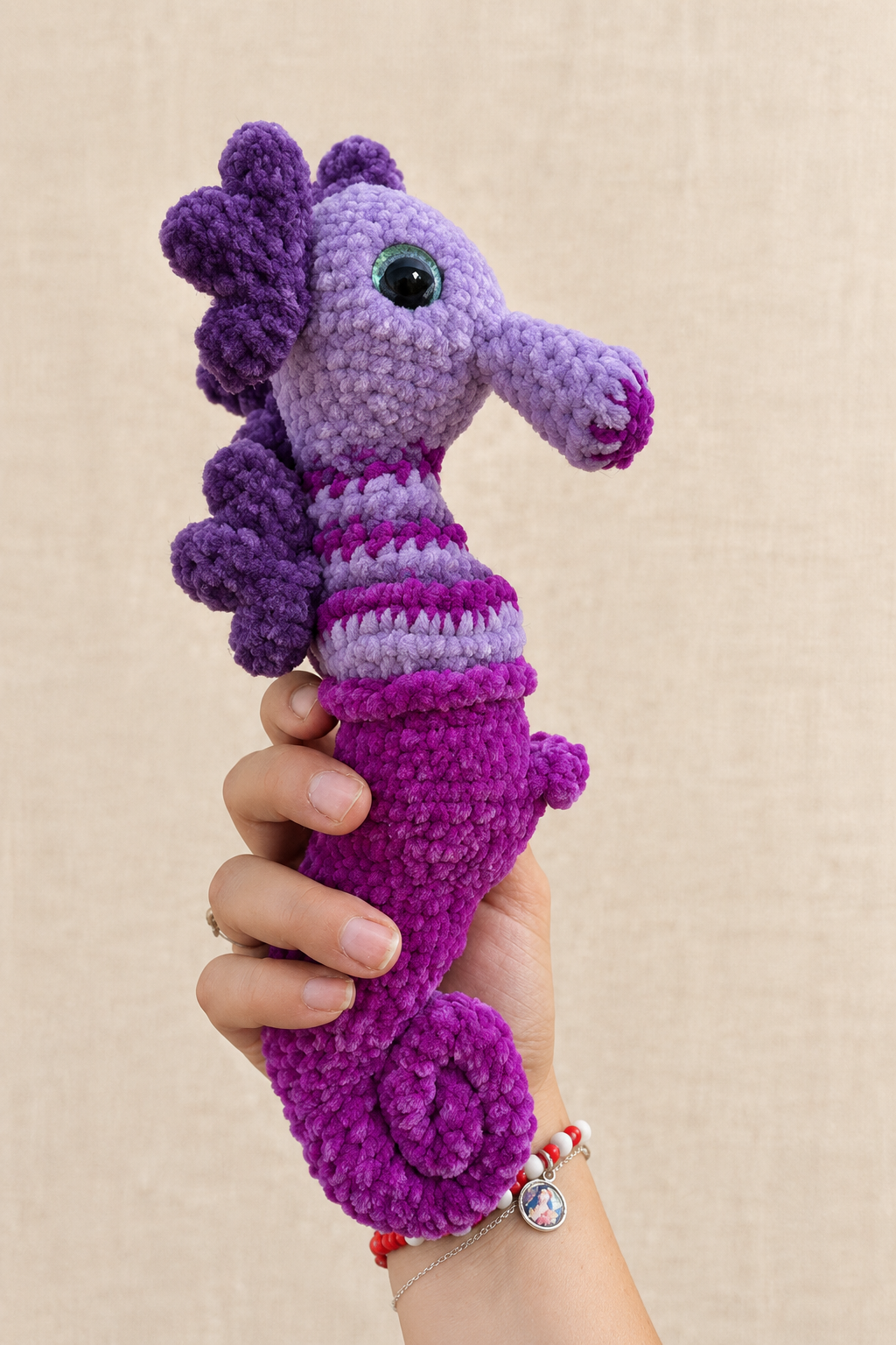 Hippocampe violet, vue de profil droit sur fond beige
