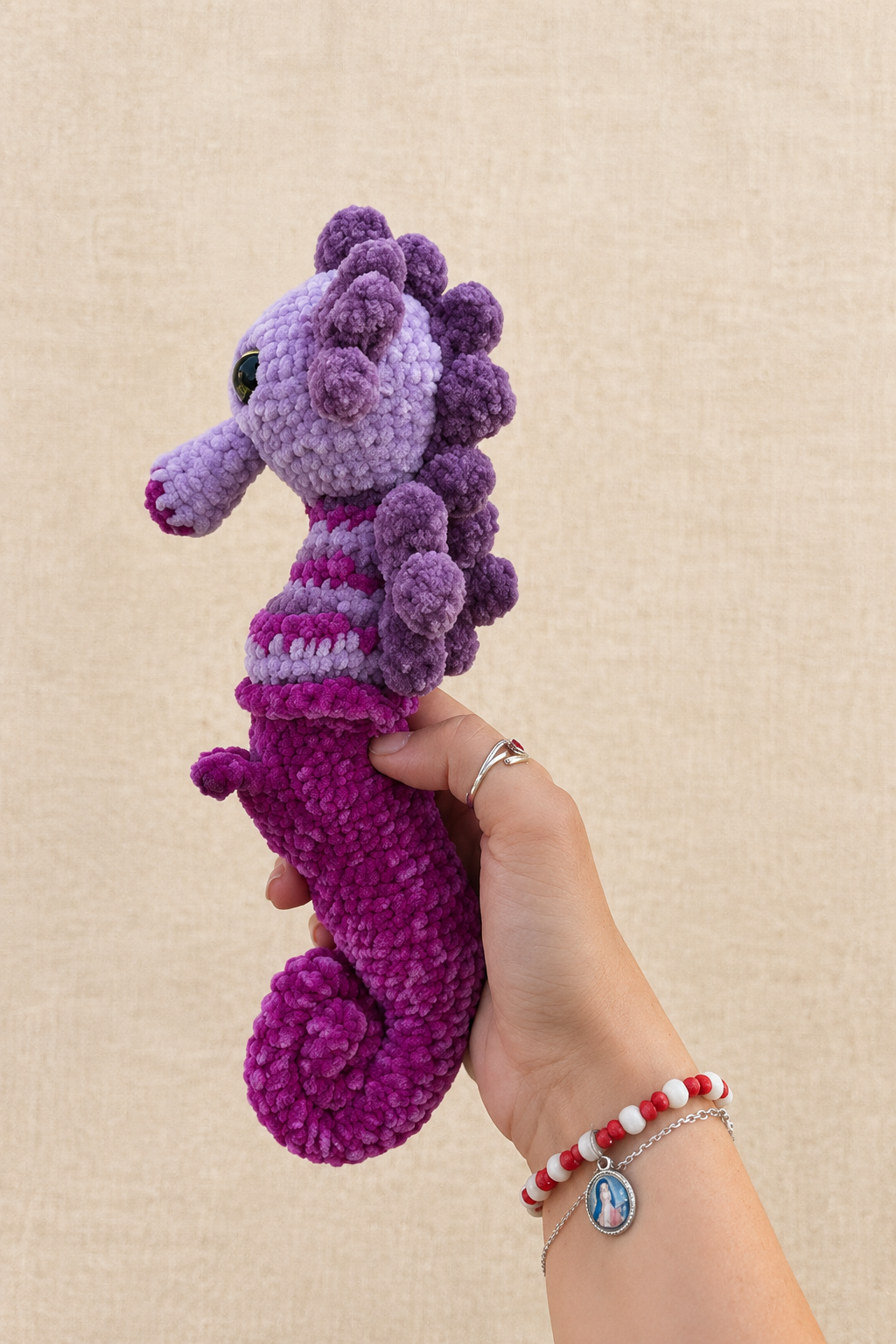 Hippocampe violet, vue de profil gauche sur fond beige